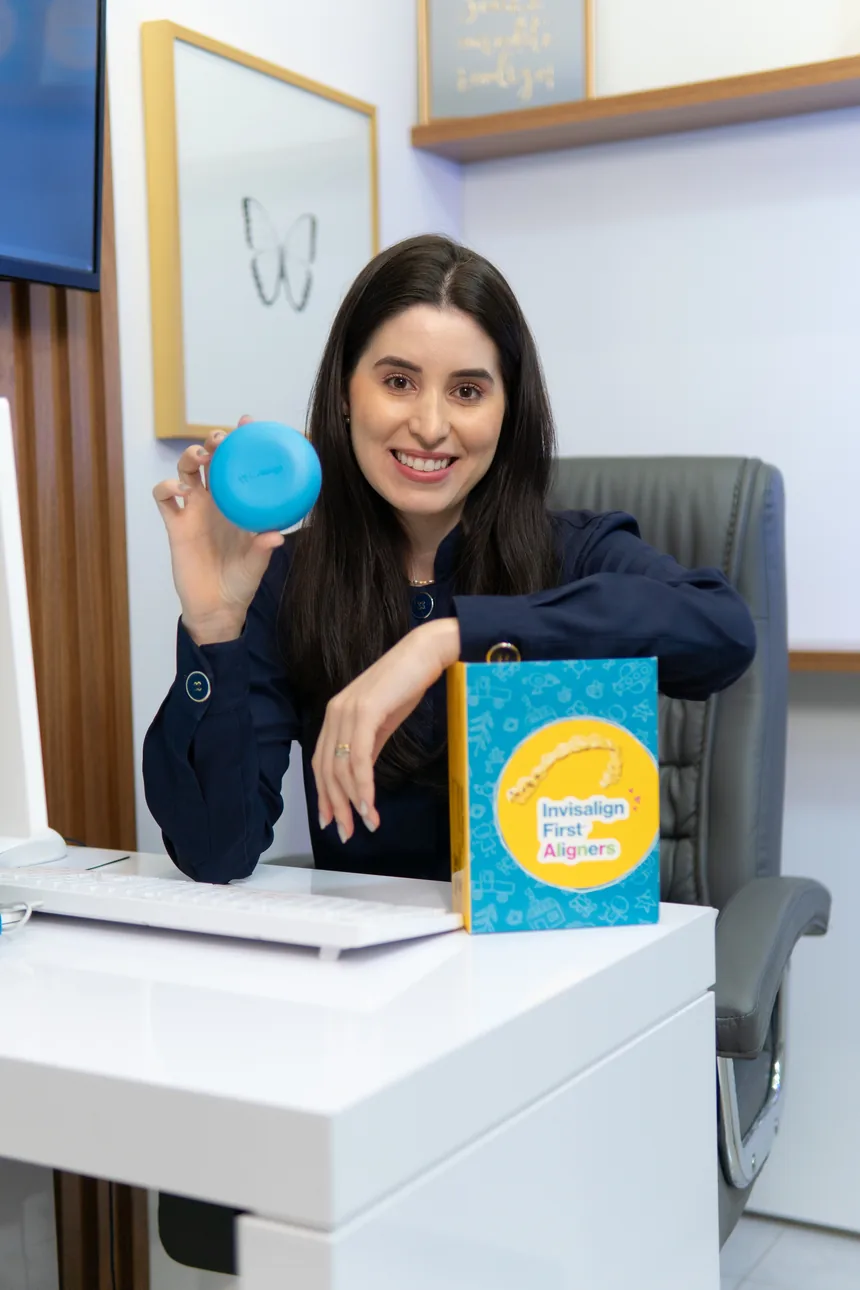 Dra. Juliana Braga no consultório com o kit Invisalign First